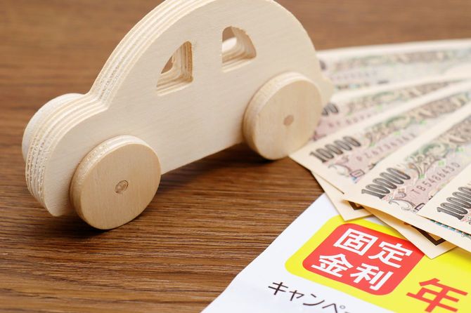 固定金利キャンペーンのチラシとミニチュアカーと現金
