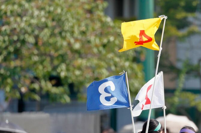 運動会にて、それぞれの順位の旗に児童たちが集まっている