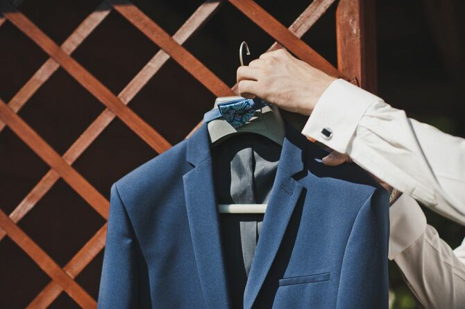 スーツをかけたハンガーを手に取る男性