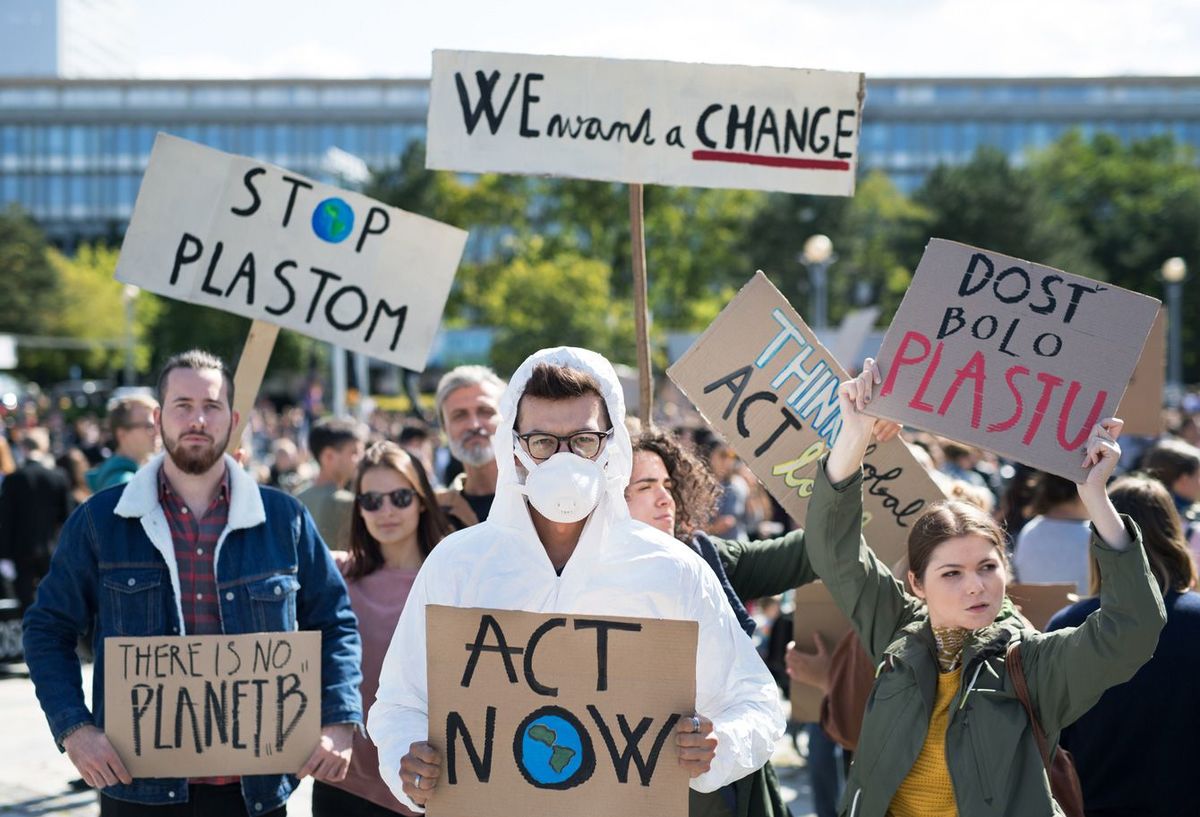 気候変動に対する世界的なストライキにプラカードと防護服を着た人々
