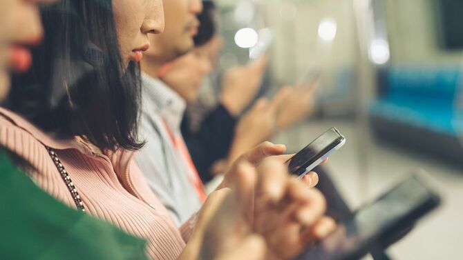 公共の地下鉄で携帯電話を使用する若者