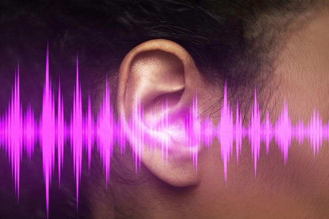 人間の耳元と音声波形のクローズアップ