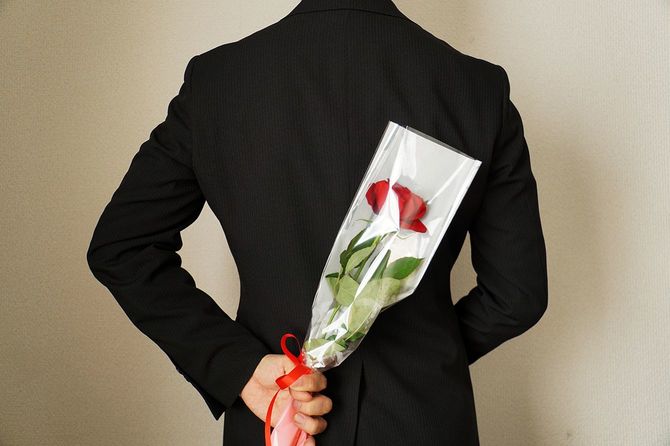 バラの花をプレゼントする男。