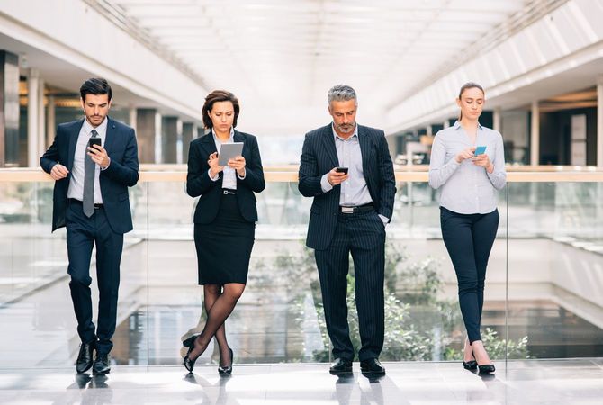 スマホでメールを送るビジネスパーソンたち