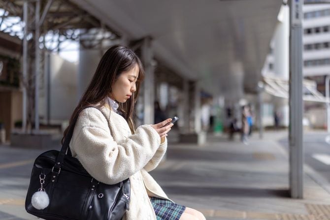 スマートフォンを使う女子高生