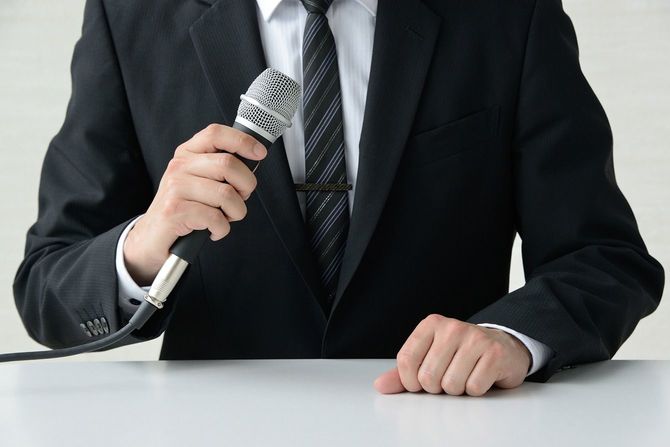 マイクを持って話す人