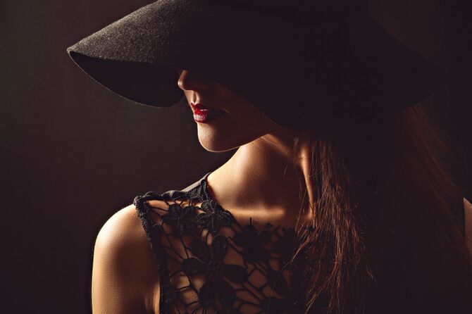 ブラックの帽子とドレスを身にまとった女性