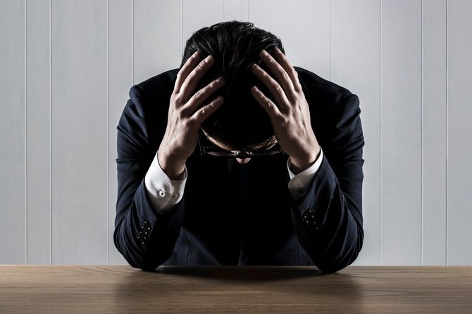 頭を抱えている男性