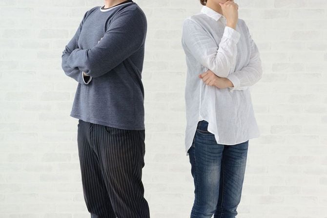 互いに背を向けて立つ夫婦