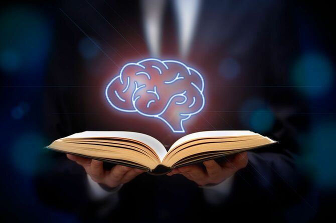 開いた本の上に脳が浮かぶイメージ