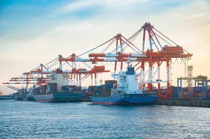 夕暮れ時の造船所に横付けされたコンテナ船