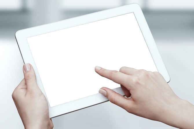 タブレット端末を手に操作している女性の手元