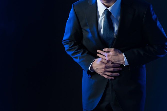 お腹の痛みに苦しむビジネスマン