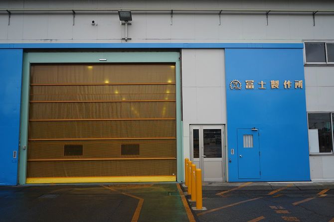 冨士製作所の工場入口。勝手口の上部には、社名とロゴマークが掲げられている