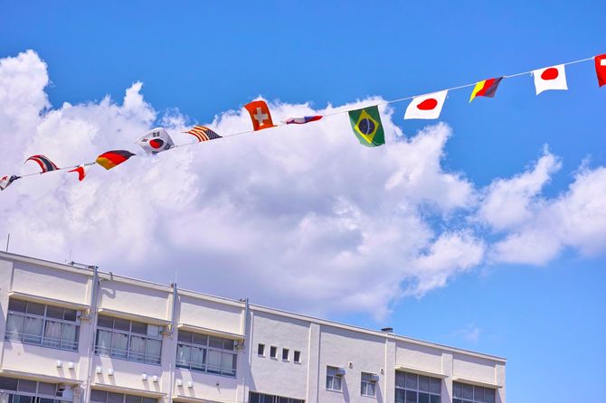 運動会の日、青空にはためく各国の国旗