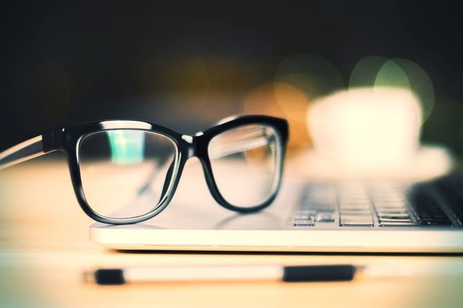 ノートパソコンの上に置かれた眼鏡