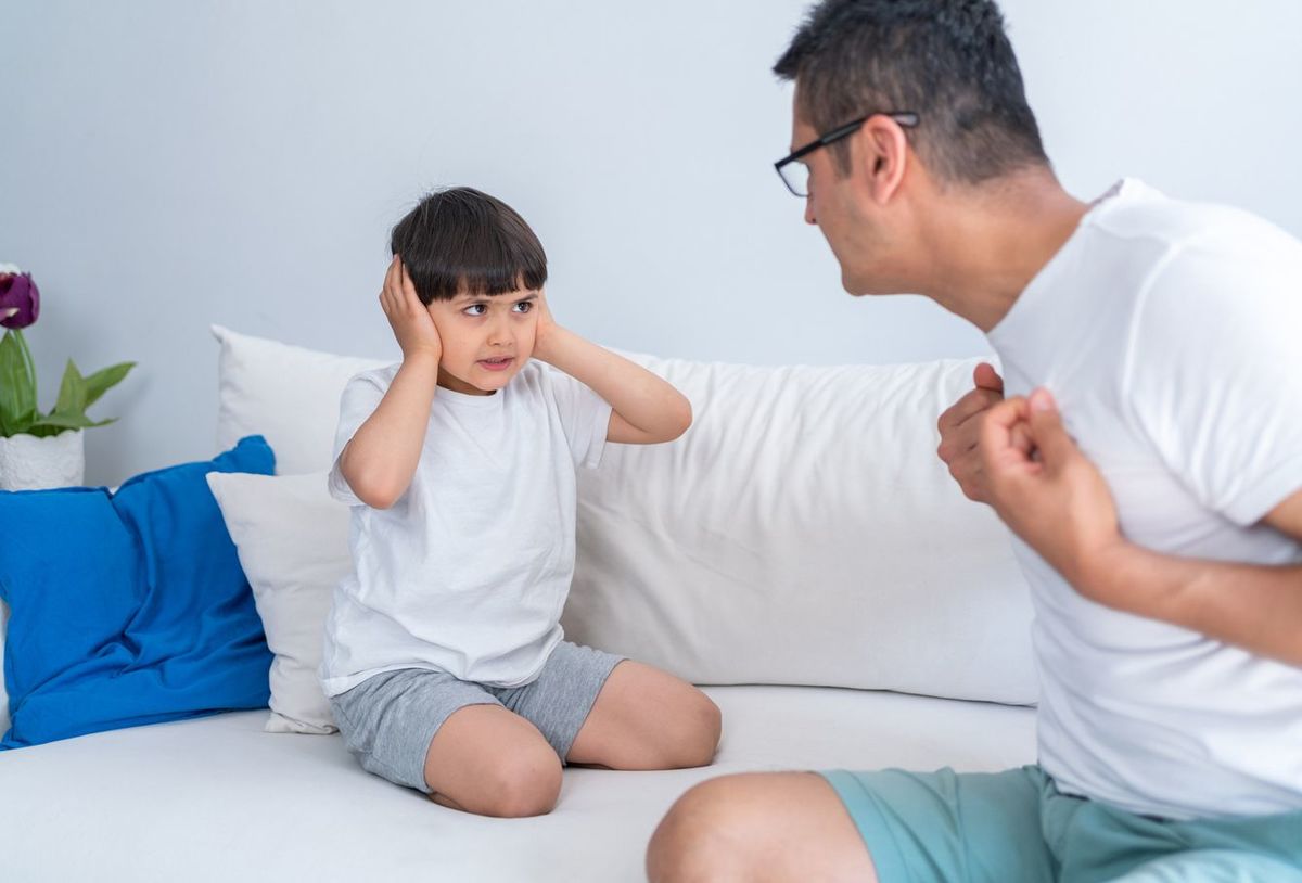 父親の言葉に耳をふさぐ少年