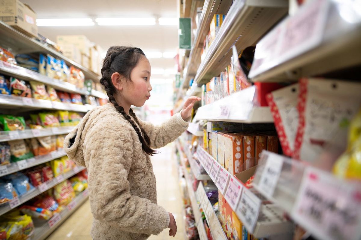 スーパーでお菓子を選ぶ女の子