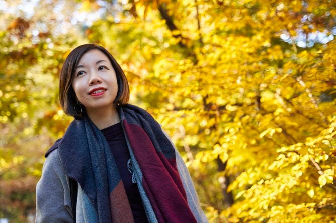 紅葉の中を歩く女性