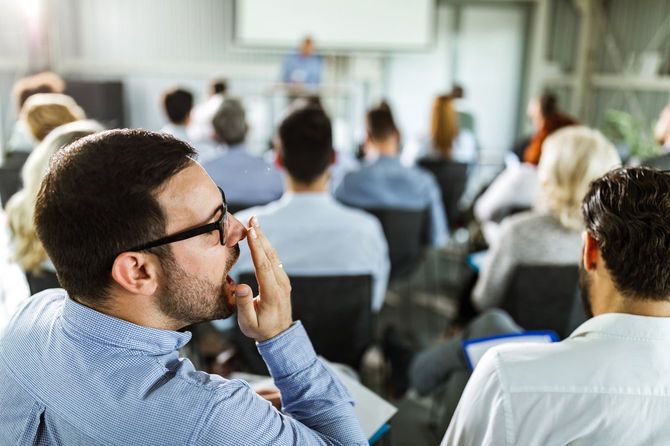 セミナーで欠伸をする男性