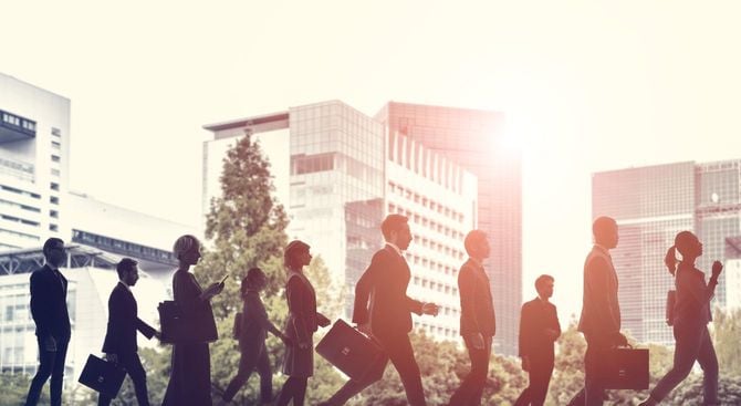 ビジネスパーソンが連なって歩くシルエット