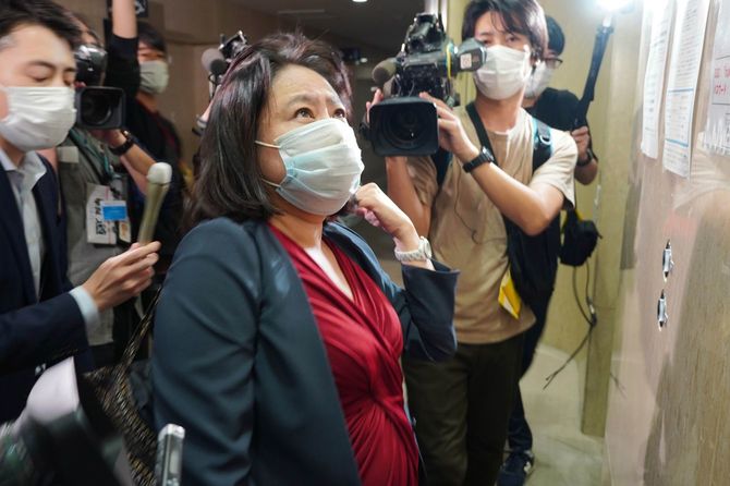 報道陣に囲まれながらエレベーターを待つ木下富美子東京都議（中央）＝2021年11月10日未明、東京都新宿区