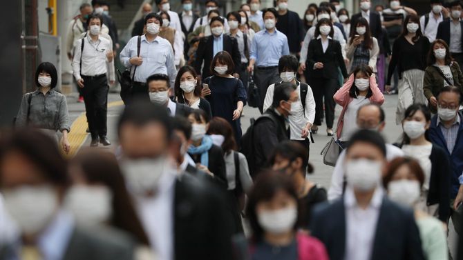 緊急事態宣言が解除されて初めての朝を迎え、多くの通勤客らが行き交う新宿駅付近＝2020年5月26日、東京都新宿区