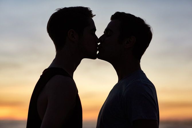 キスをする男性同士のシルエット