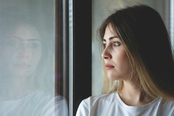 窓で泣いている不幸な女性