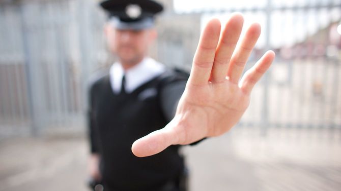 警備員が手のひらをこちらに向け停止するようにサイン