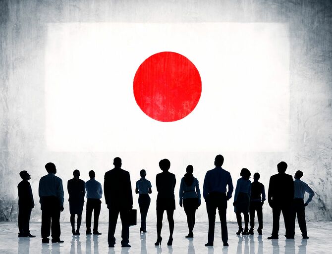 日本の国旗を見上げる人々