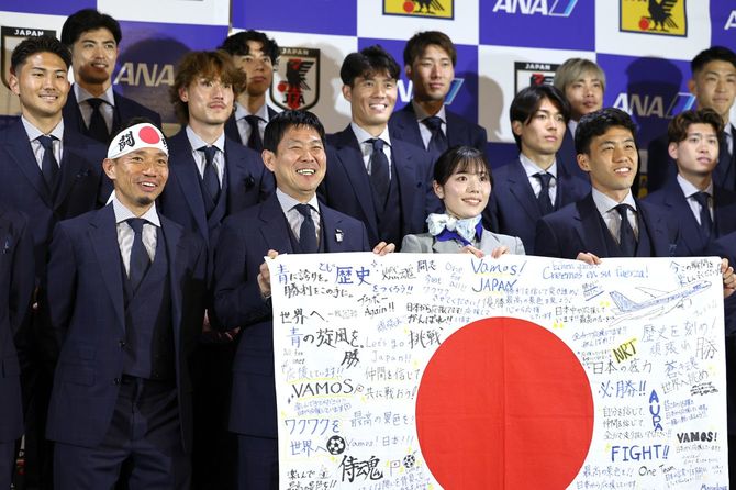 ワールドカップ（W杯）出発セレモニーで記念撮影する日本代表の選手ら。前列左端は日の丸鉢巻きを巻いた長友佑都。同左から2人目は森保一監督＝2026年6月2日、千葉・成田空港