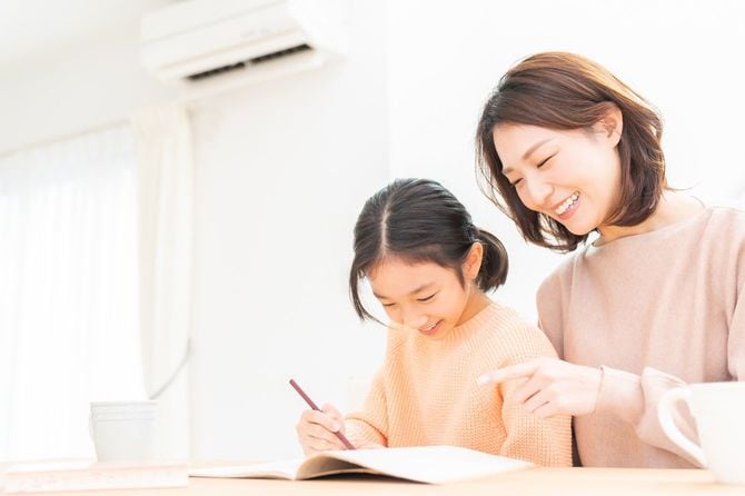 勉強する娘に寄り添う母親