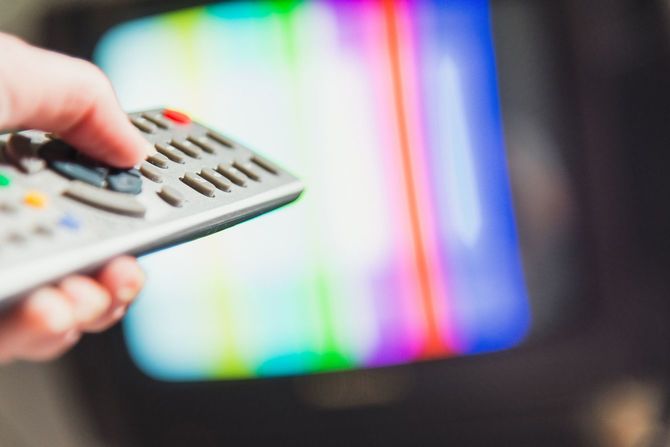テレビのリモコンを持つ手元