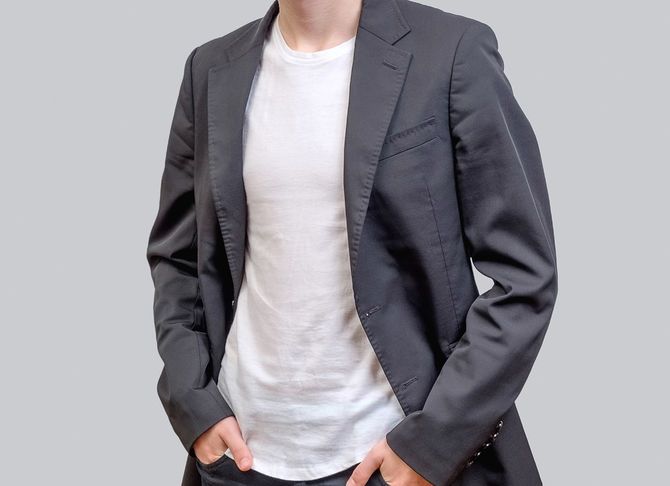 Tシャツにジャケットを羽織った人のイメージ