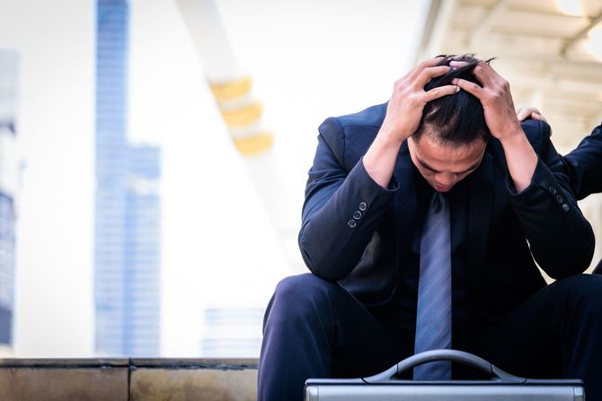 ストレスにかられ頭を抱えるビジネスマン