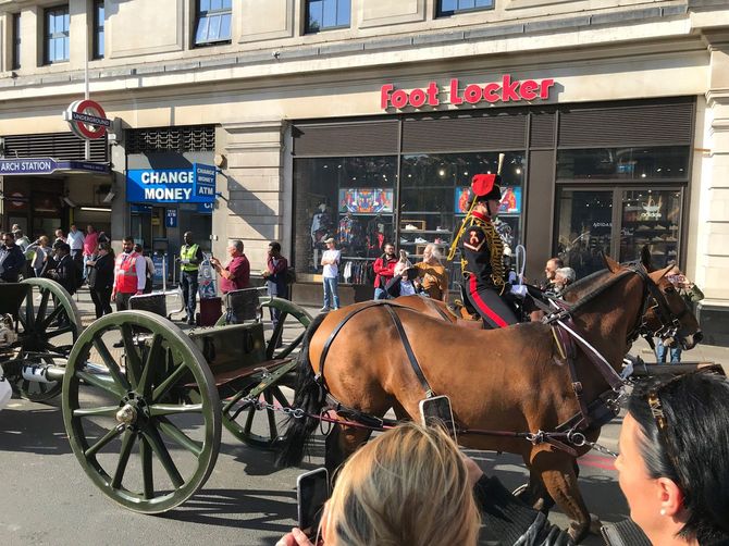 弔砲を撃つ大砲が馬に引かれて繁華街を走る