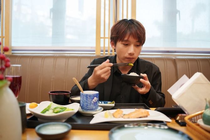 日本食を食べるアジア人男性