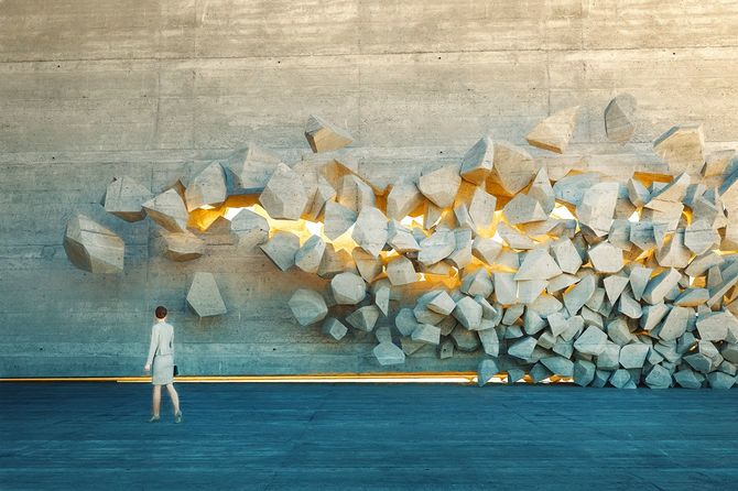 壁を壊す前に立つビジネスウーマン