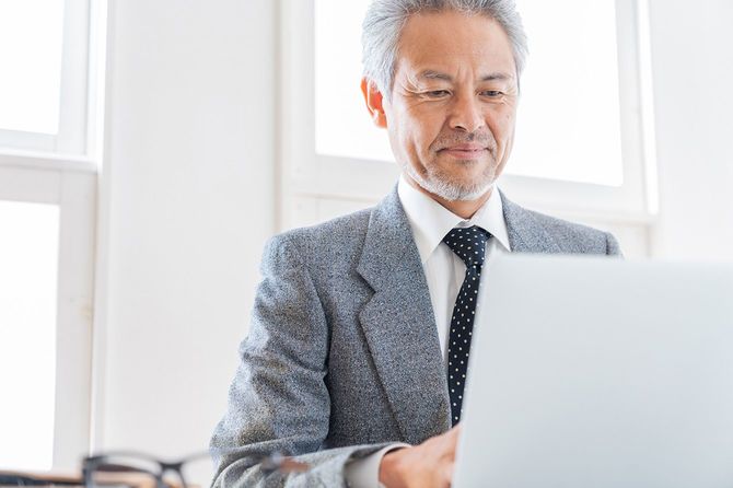 パソコンを使用する高齢のビジネスマン