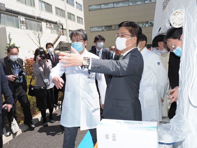 新型コロナウイルスの感染拡大を受け、国立国際医療研究センターの敷地内に設置された「新型コロナ検査スポット」を視察する加藤勝信厚生労働相(手前右)=2020年4月23日、東京都新宿区