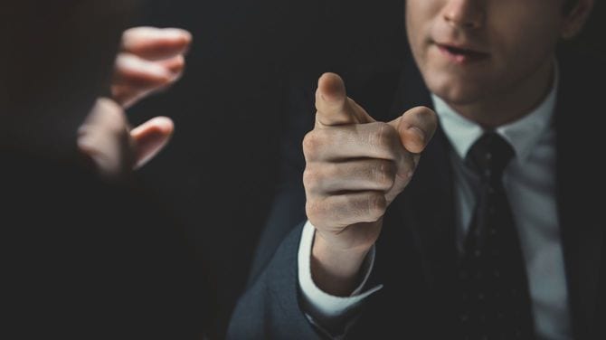 暗い部屋のなかで詰問する男性