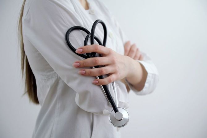 白い背景に聴診器を持つ女性医師