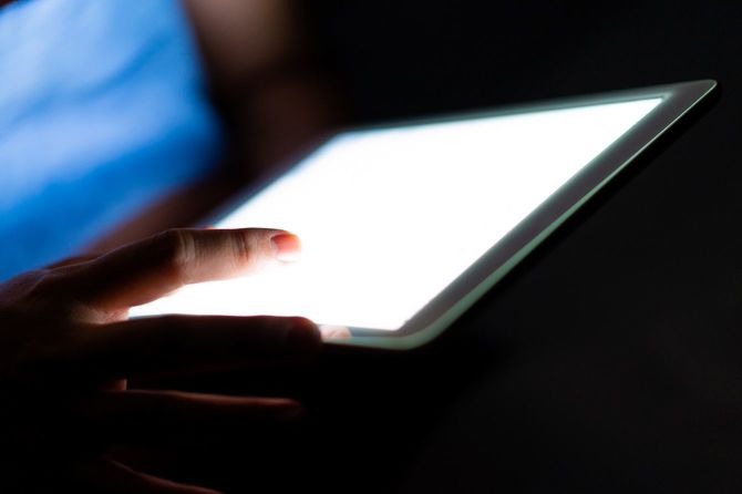 暗い部屋でタブレットを見ている女の子