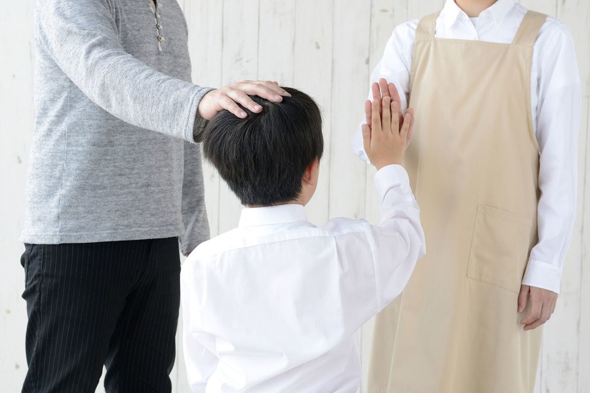 子供の頭をなでる親