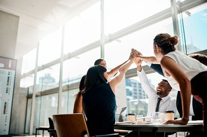 ハイタッチをする仕事のチーム