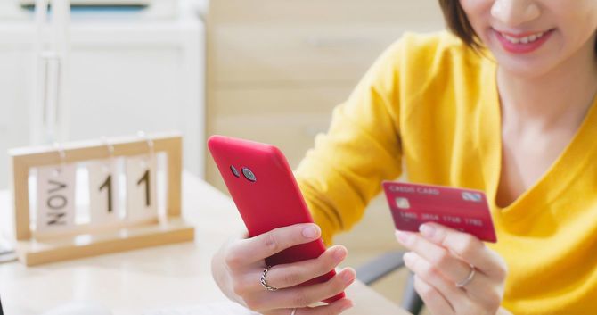 中国の「独身の日」にスマホで買い物をする女性