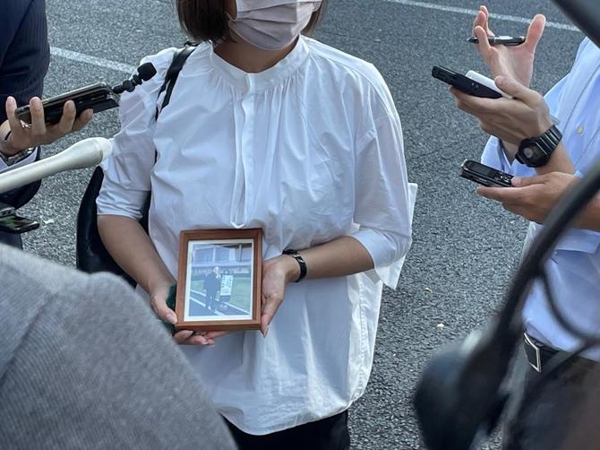 赤木俊夫さんの遺影を手にピンクのマスク姿の雅子さん