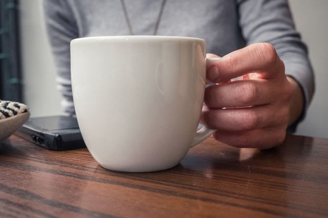 マグカップを傾ける手元