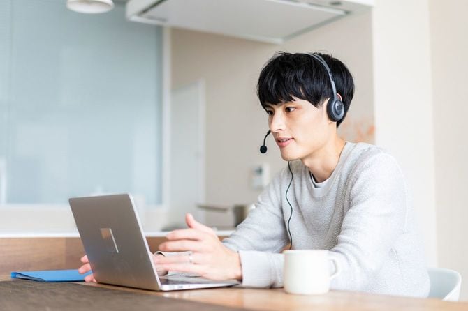 インカムを付けノートパソコンに向かっている男性